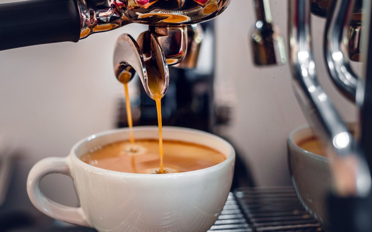 An espresso machine pouring coffee